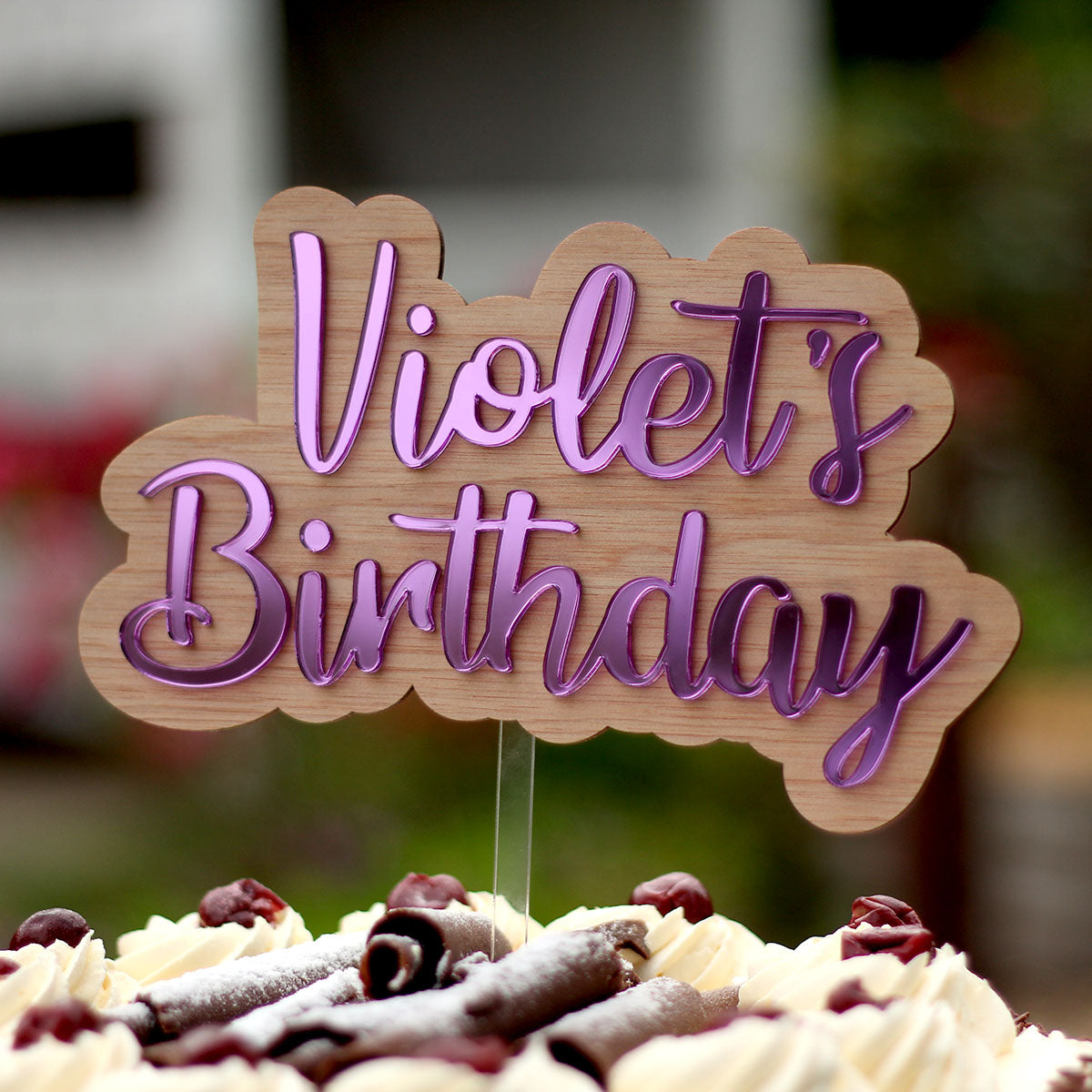 acrylic and wood cake topper with purple mirror words "Violet's birthday"